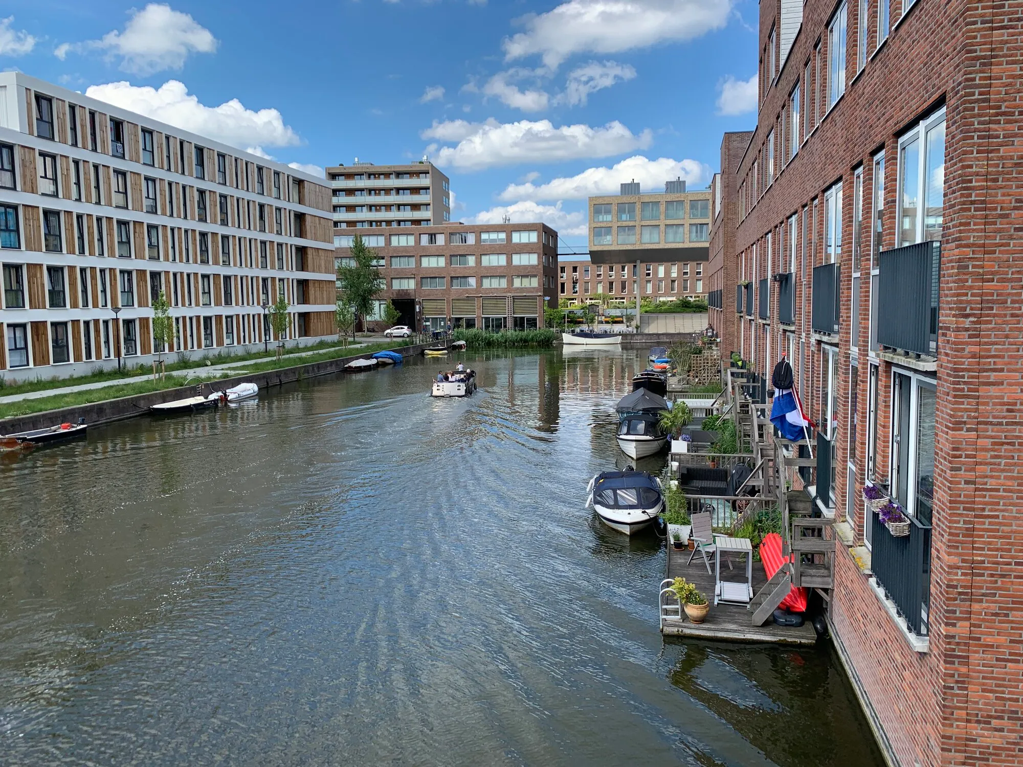 A building on water with small terraces on the back of it so you can park a small boat