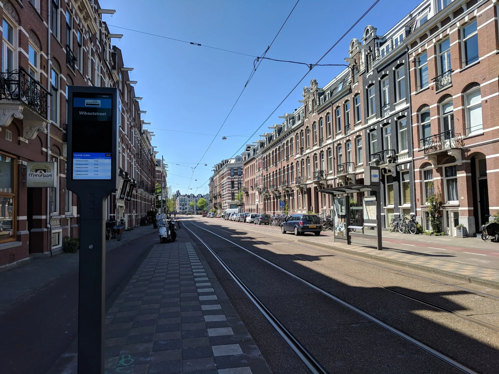 Amsterdam's street with only one line for cars and the rest is for trams, bicycles, and pedastrians