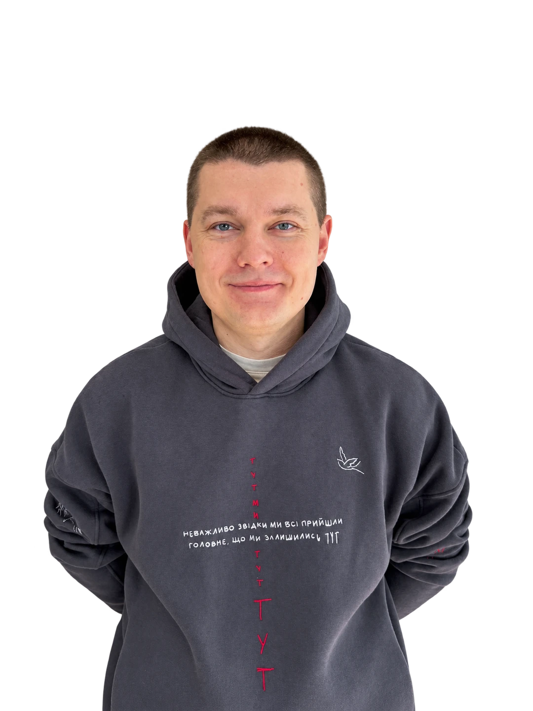 Dima standing in a blue embroidered hoodie with his hands behind his back