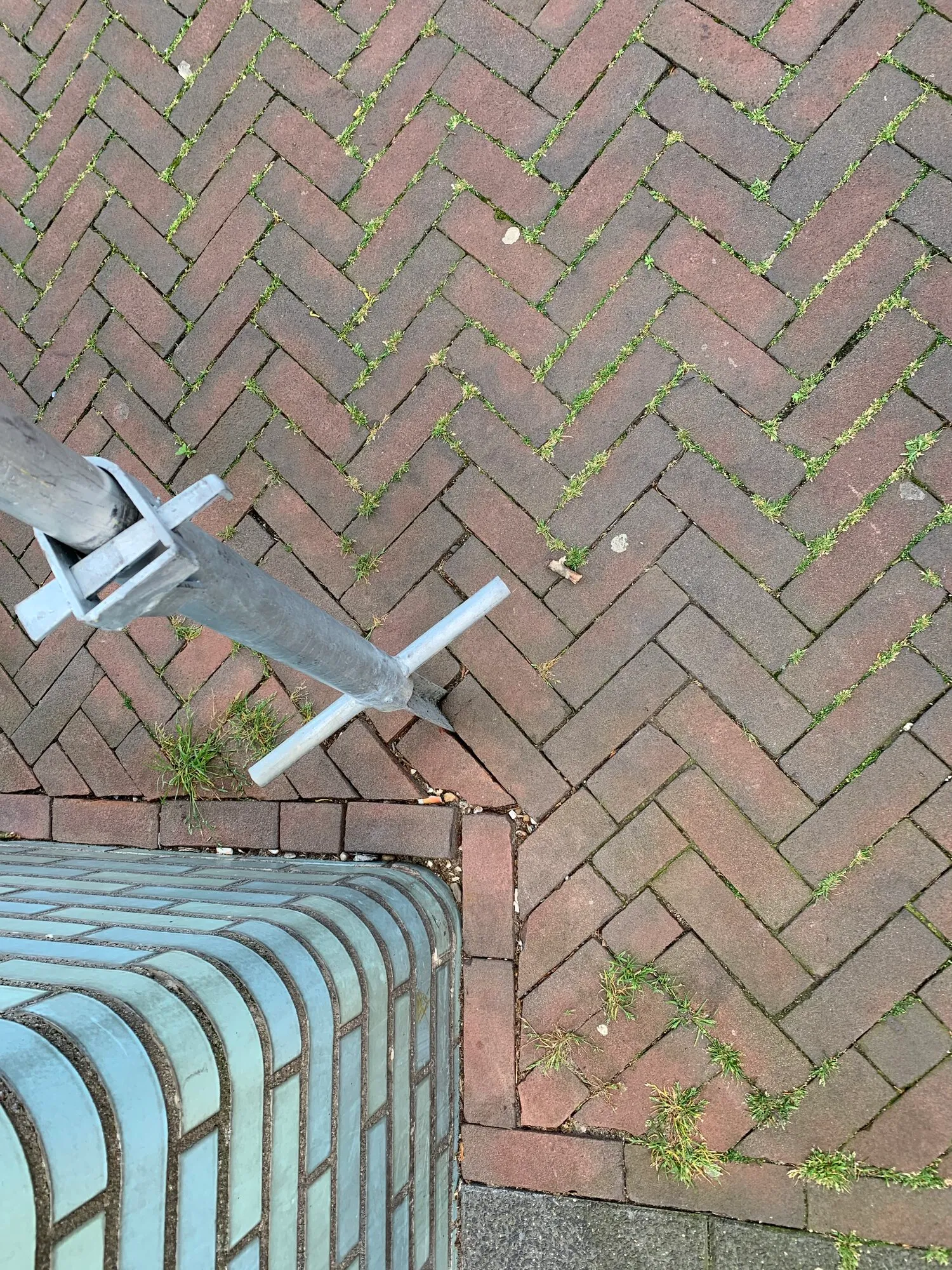 A closer look at how the sign is inserted between the tiles on a sidewalk